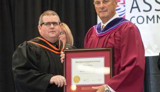 Jim Treliving (right) accepts his Assiniboine Community College Honorary Diploma from President Mark Frison in June 2014.
