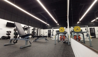 Weight lifting room of the Fitness Centre with lifting benches in front of a mirror.