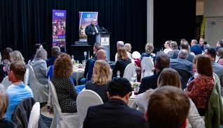 Assiniboine College president, Mark Frison, delivering a speech in front of a seated crowd.