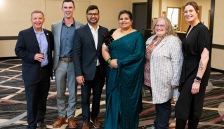 Six event guests standing together and smiling at the camera.