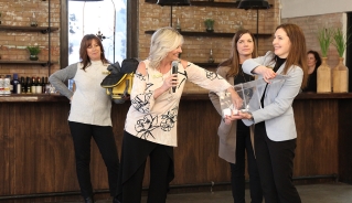 Four Assiniboine College Alumni board of directors members pulling a contest winner name out of a box.