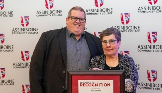 Cindy Shroeder holding her Excellence in Education Award certificate, standing with Assiniboine president, Mark Frison.