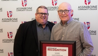 Scott Willing holding an Excellence in Education Award certificate, standing with Assiniboine president, Mark Frison.