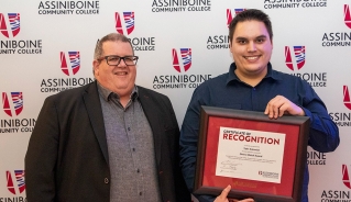 Tyler Antoniuk holding a One to Watch Award certificate, standing with Assiniboine president, Mark Frison.