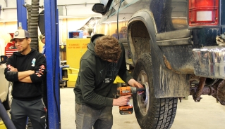 A high school student changing a tire.