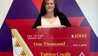 Elizabeth B. holding a big red cheque.