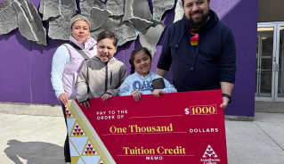 Emely S. and family holding a big red cheque.