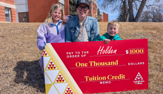 Holden S. and family holding a big red cheque.