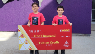 Jake and Jaden M. holding a big red cheque.