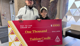 Nazar D. holding a big red cheque.