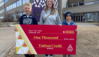 Zachary G. and family holding a big red cheque.