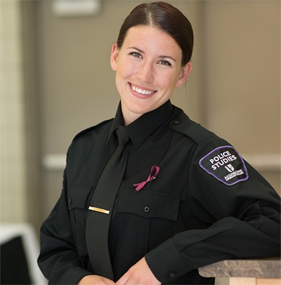 Brooke stands facing camera with police studies uniform.