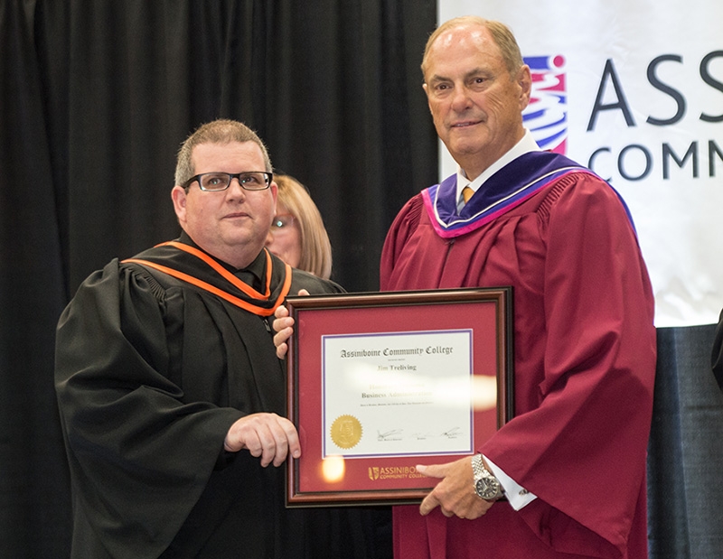 Jim Treliving accepts his Assiniboine Community College Honorary Diploma from President Mark Frison