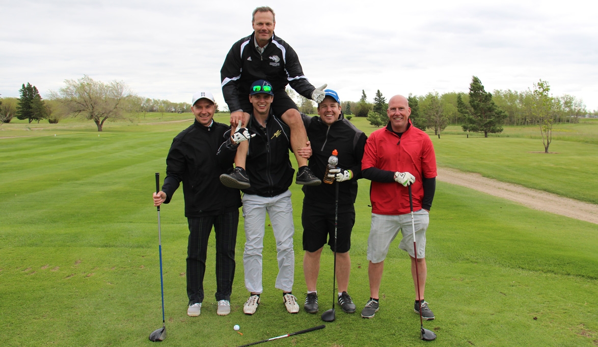 Golfers stand on golf course.