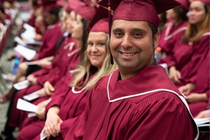 Students in graduation gowns looking at the camera