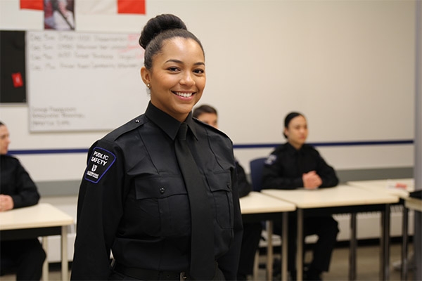 Ravyn Duncan standing in a classroom in her Public Safety uniform