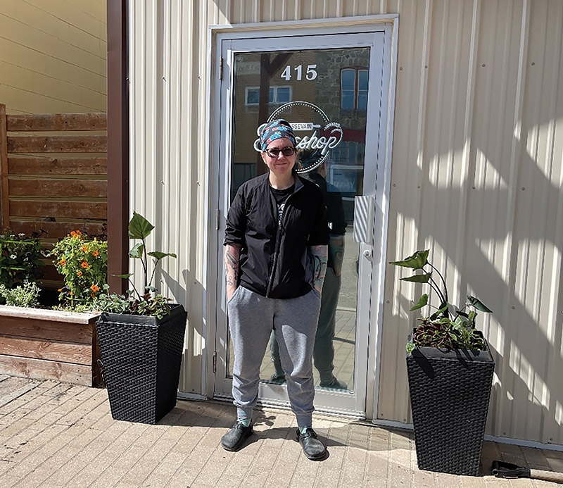 Alannah Moody standing in front of the door to her bakeshop on a sunny day.