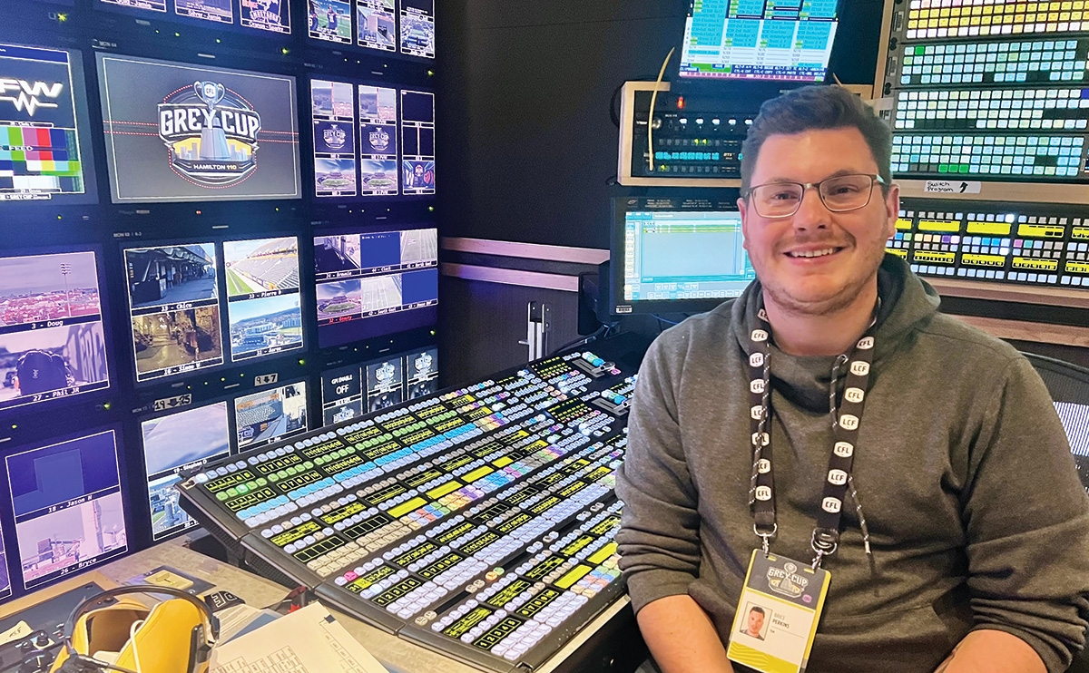 Brice Perkins sitting in a production suite in front of a switcher and a wall of screens.