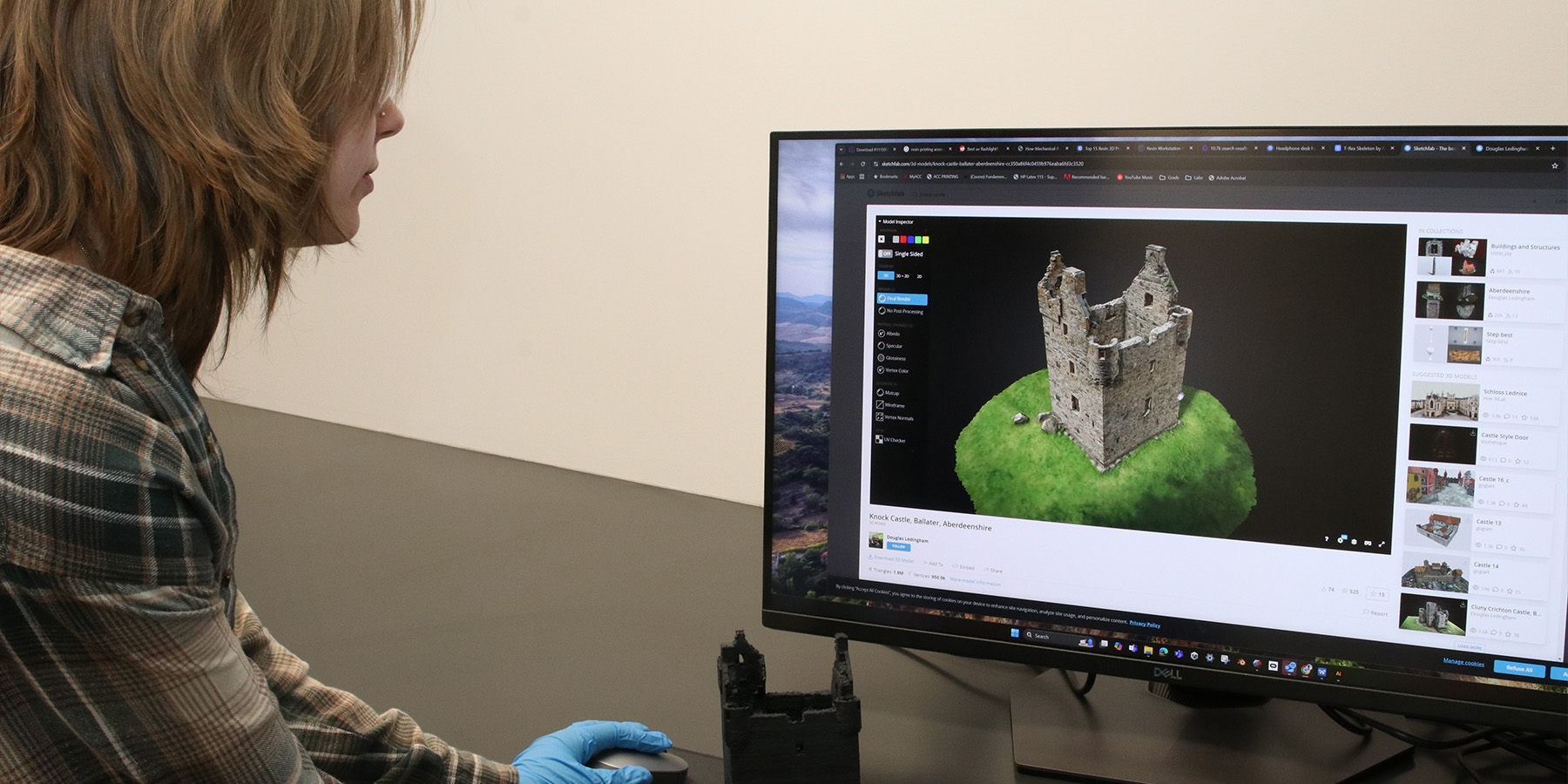 A person looking at a 3D model on a computer while holding a printed one in their hand.