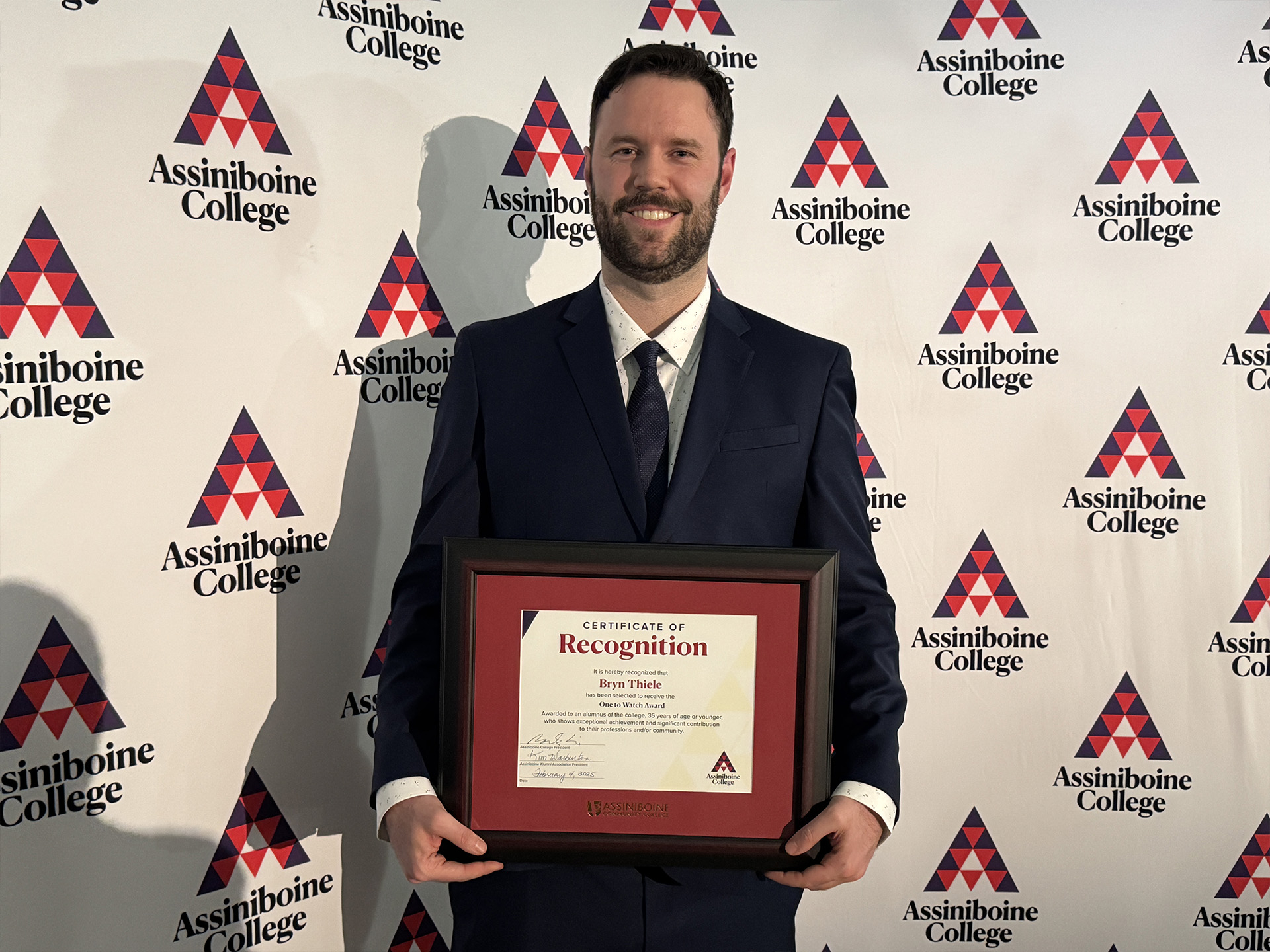 Bryn Thiele posing with his Alumni Awards certificate.