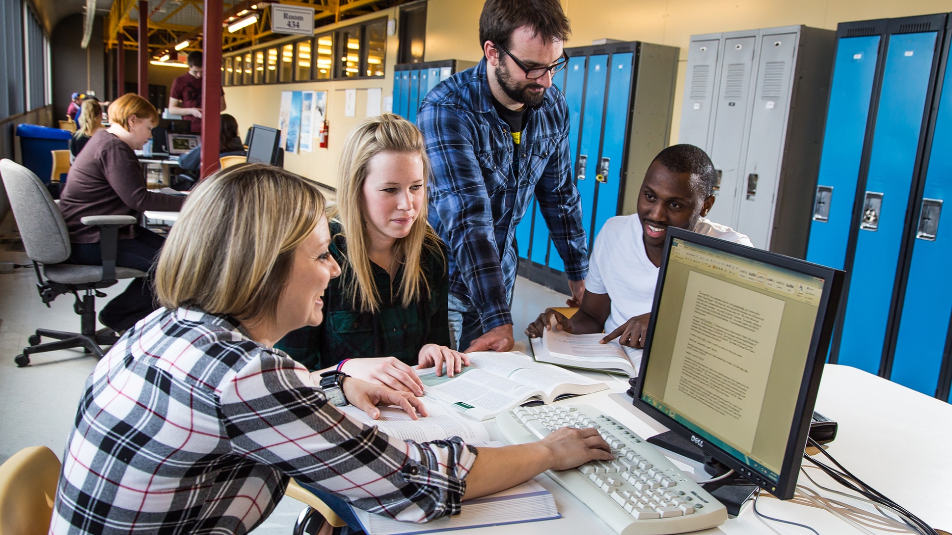 group of students sitting around a computer