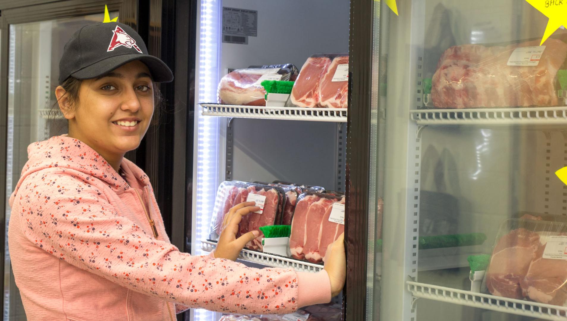 Assiniboine student inspects meat fridges
