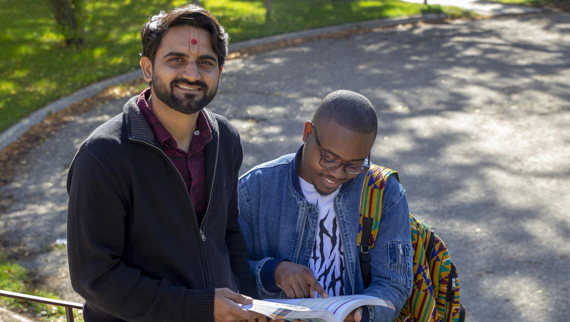 two international students reading a book