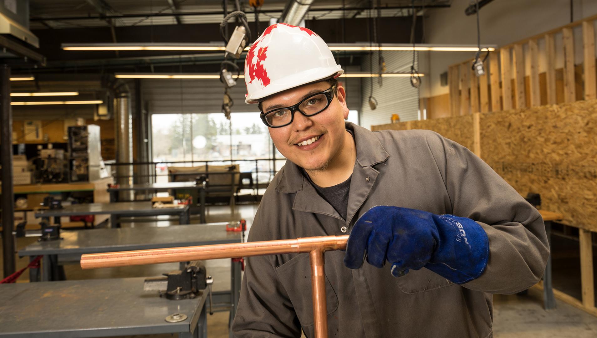 Piping Trades student holding a copper pipe
