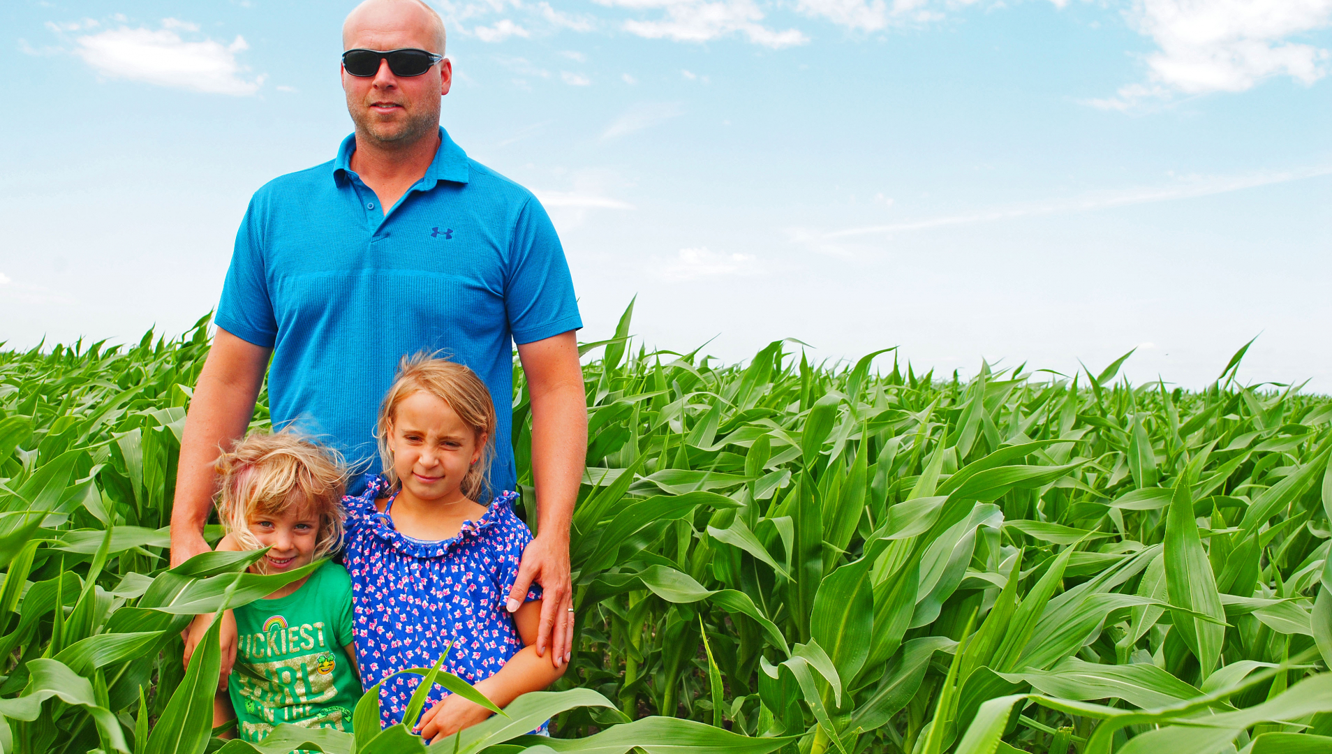 Hodson and his daughters stand amongst his crop