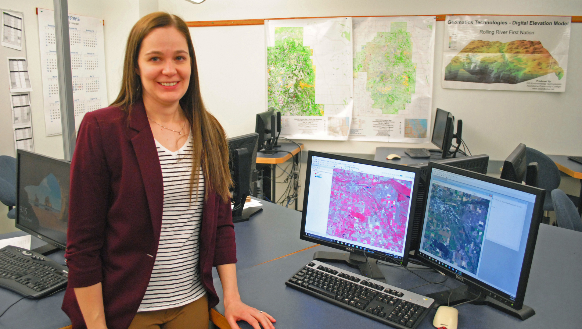 Pamela Wilson stand beside her computer showing a GIS image.