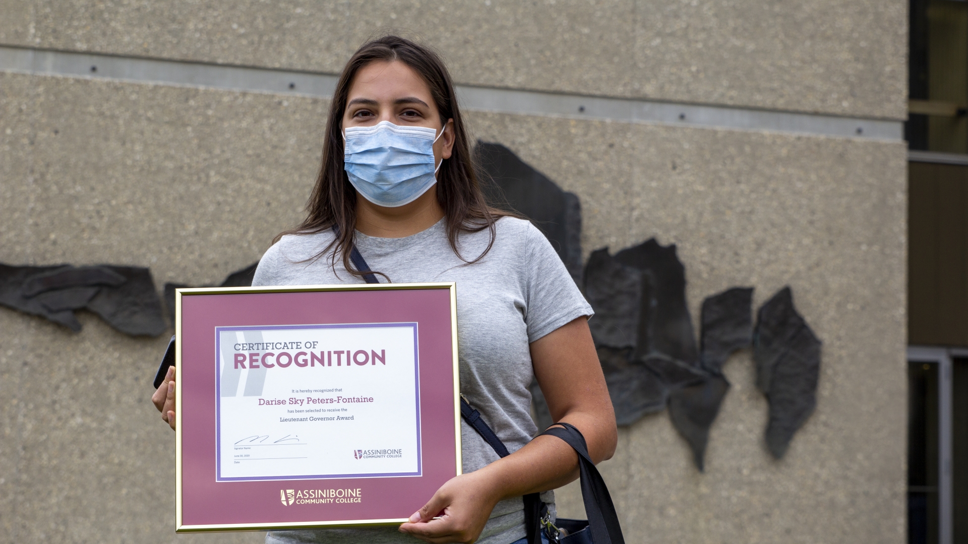 Darise Peters-Fontaine poses outside Assiniboine Community college with her Lieutenant Governor's Silver Medal certificate