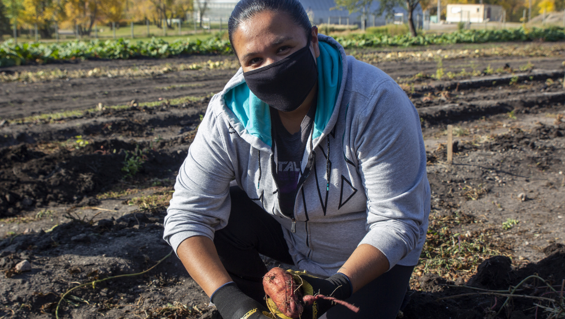 Horticultural Production student, Kateri Hope Roulette, poses for a photo with a sweet potato she's harvested