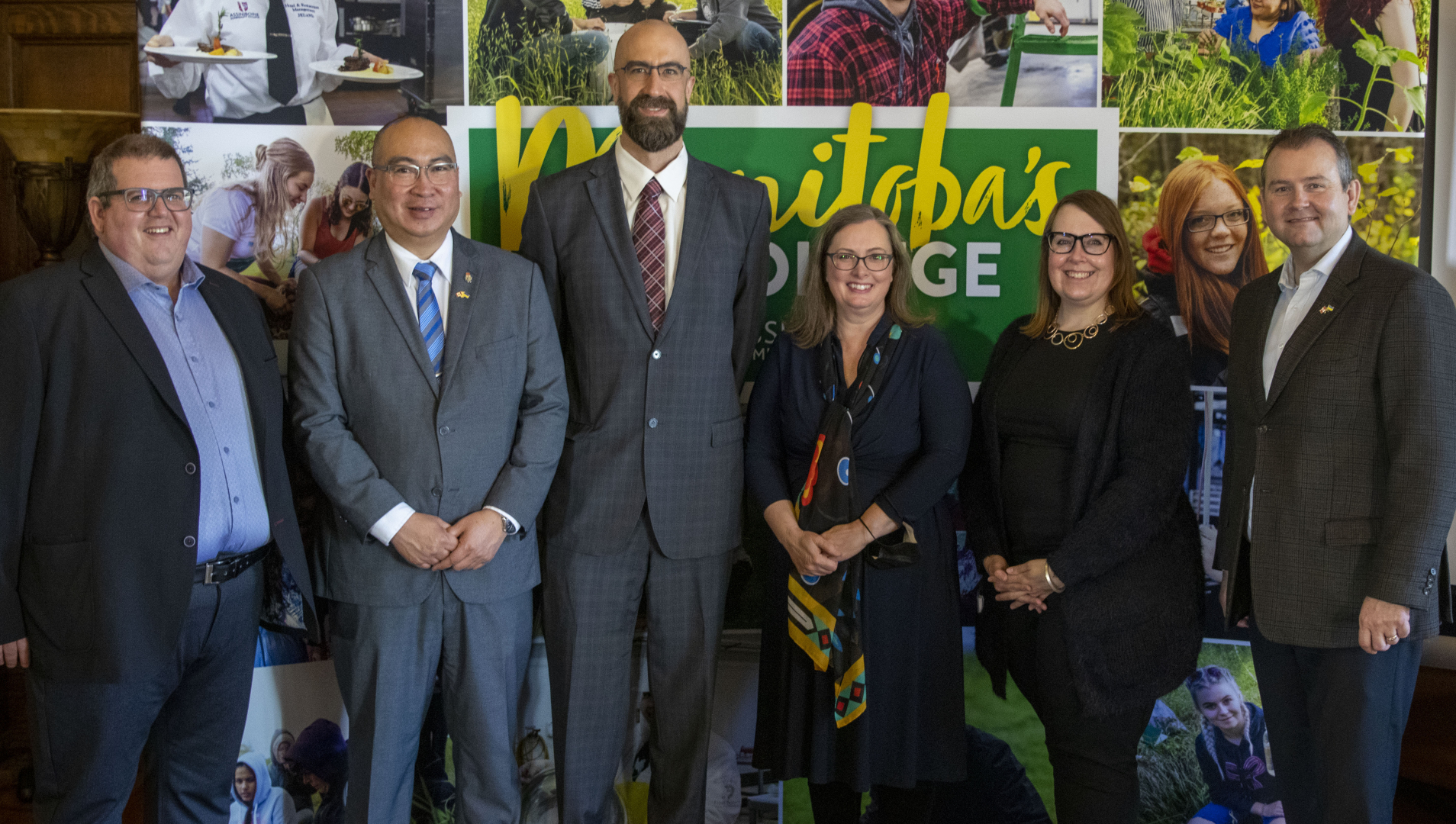 Mark Frison, Minister Jon Reyes, Brent Wennekes, Dr. Deanna Rexe, Michelle Finley and Minister Wayne Ewasko stand in front of a backdrop of student photos