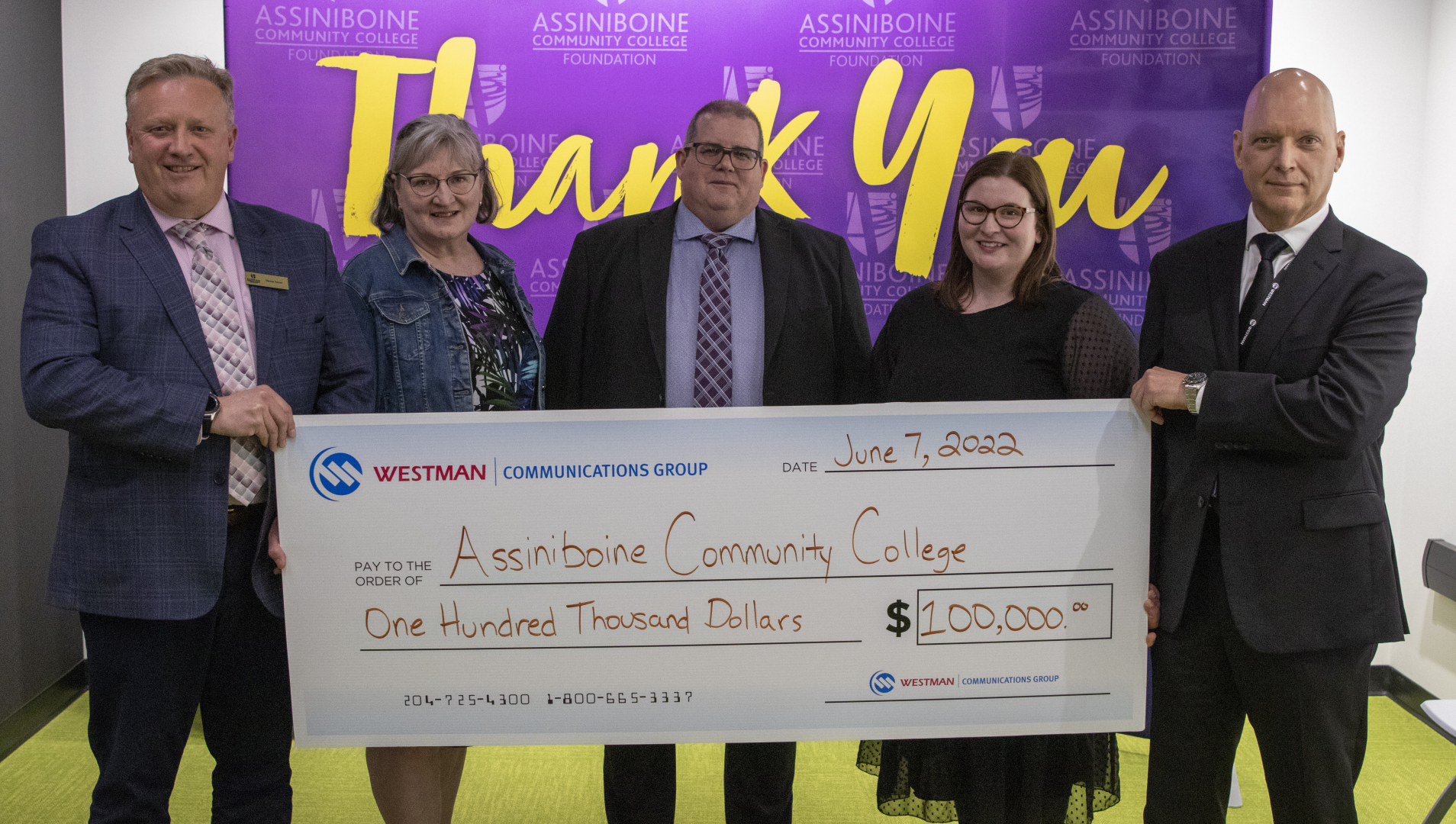 D Turner, B Robertson, M Frison, J Sproule and T Berube stand with a presentation cheque for $100K from Westman Communications Group to Assiniboine Community College