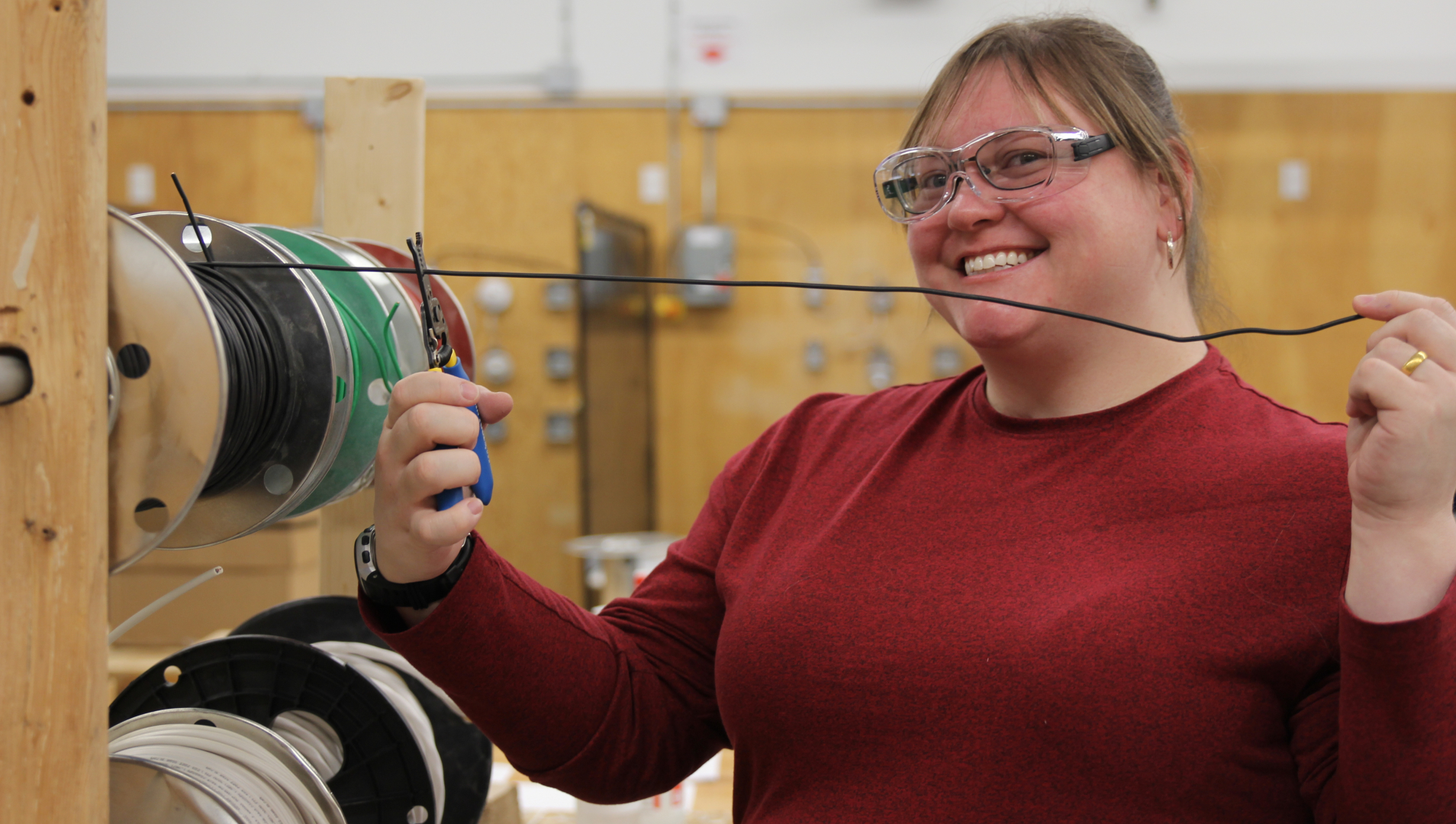 A student prepares to cut an electrical wire. 