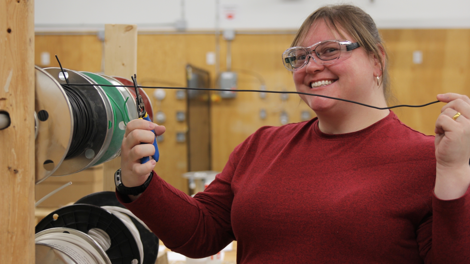 A student prepares to cut an electrical wire. 