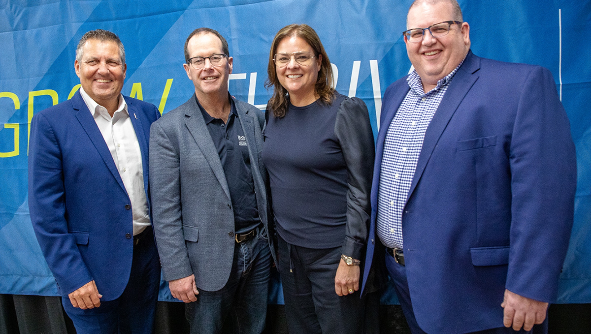 L-R (standing together in front of a blue backdrop): Honourable Cliff Cullen, Deputy Premier of Manitoba;  Tim Hore, Dean, Russ Edwards School of Agriculture and Environment, Assiniboine; Honourable Heather Stefanson, Premier of Manitoba;  Mark Frison, President, Assiniboine 