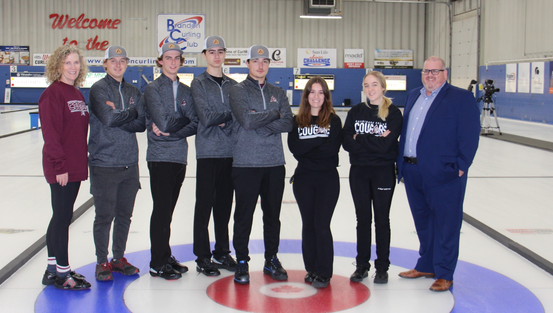 Members of the Women's and Men's Cougars Curling teams with coach Maureen Bonar and Assiniboine president Mark Frison