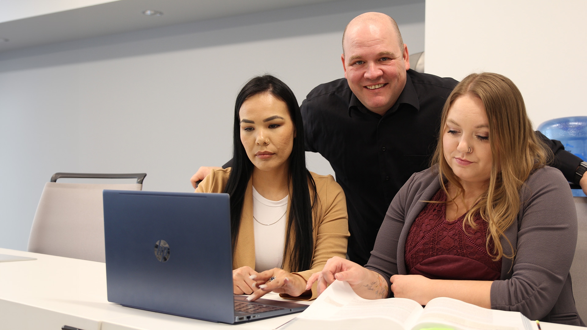 Three business students studying together in a classroom.