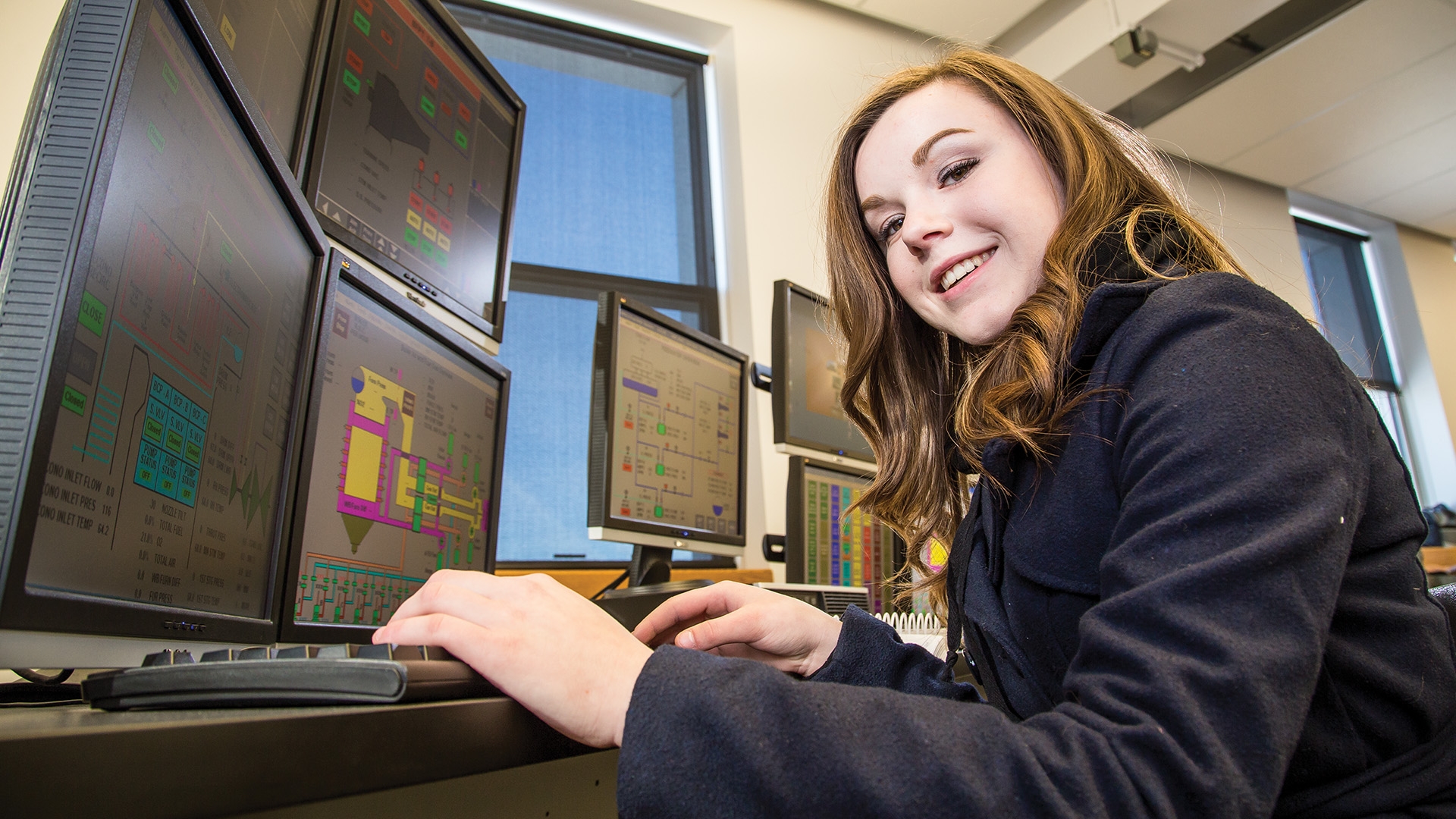 A female power engineering student working at a computer.