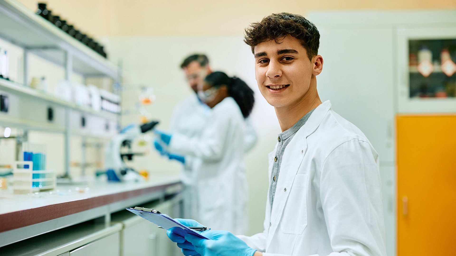 Happy biochemistry student during lab research looking at camera.