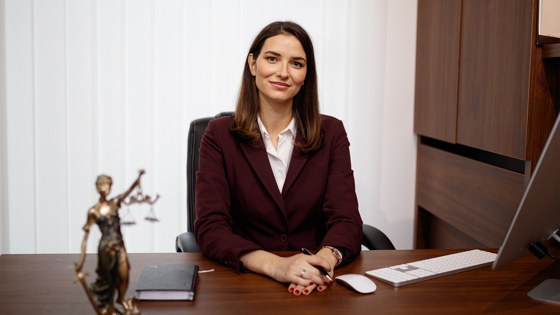 A female legal administration professional sitting at a desk.