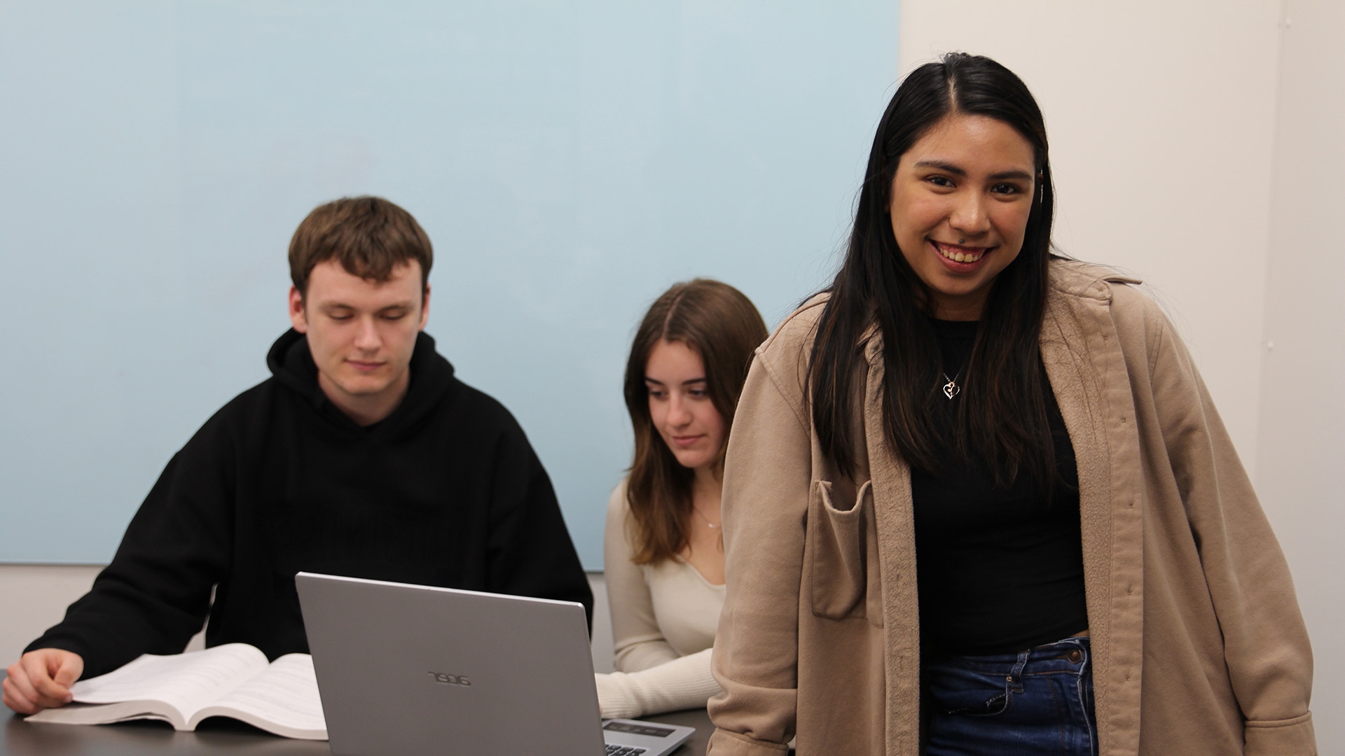 Student leaning on desk and smiling