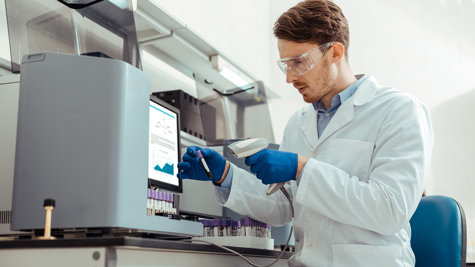 Medical lab technologist scanning a barcode on a vial.