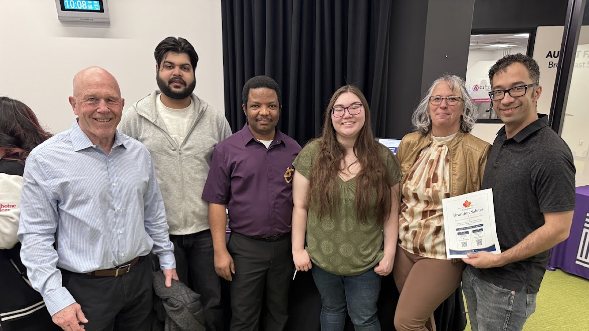 Chairperson of Brandon Salutes Barry Cooper along with board members of Brandon Salutes with Assiniboine College students