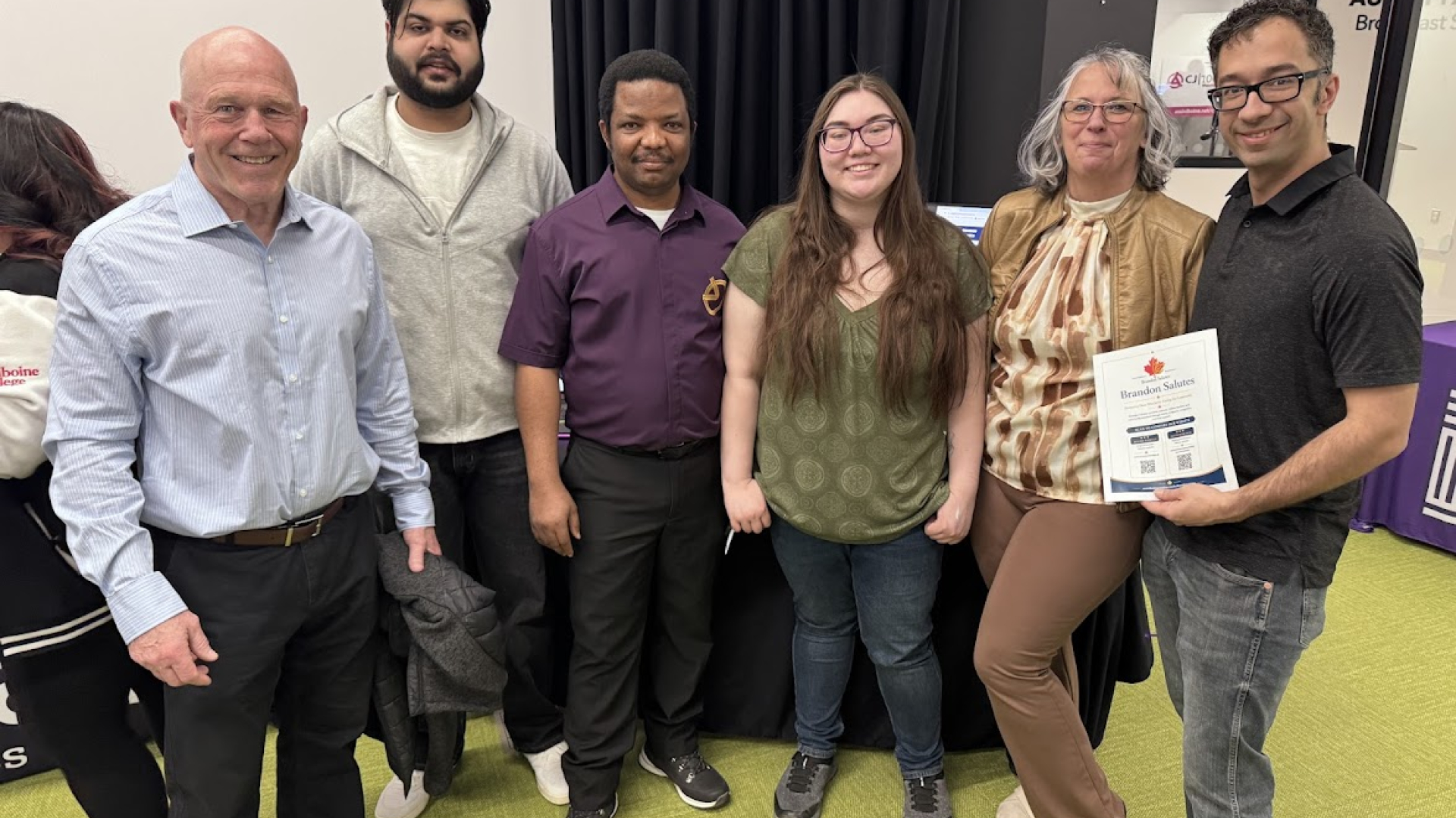 Chairperson of Brandon Salutes Barry Cooper along with board members of Brandon Salutes with Assiniboine College students