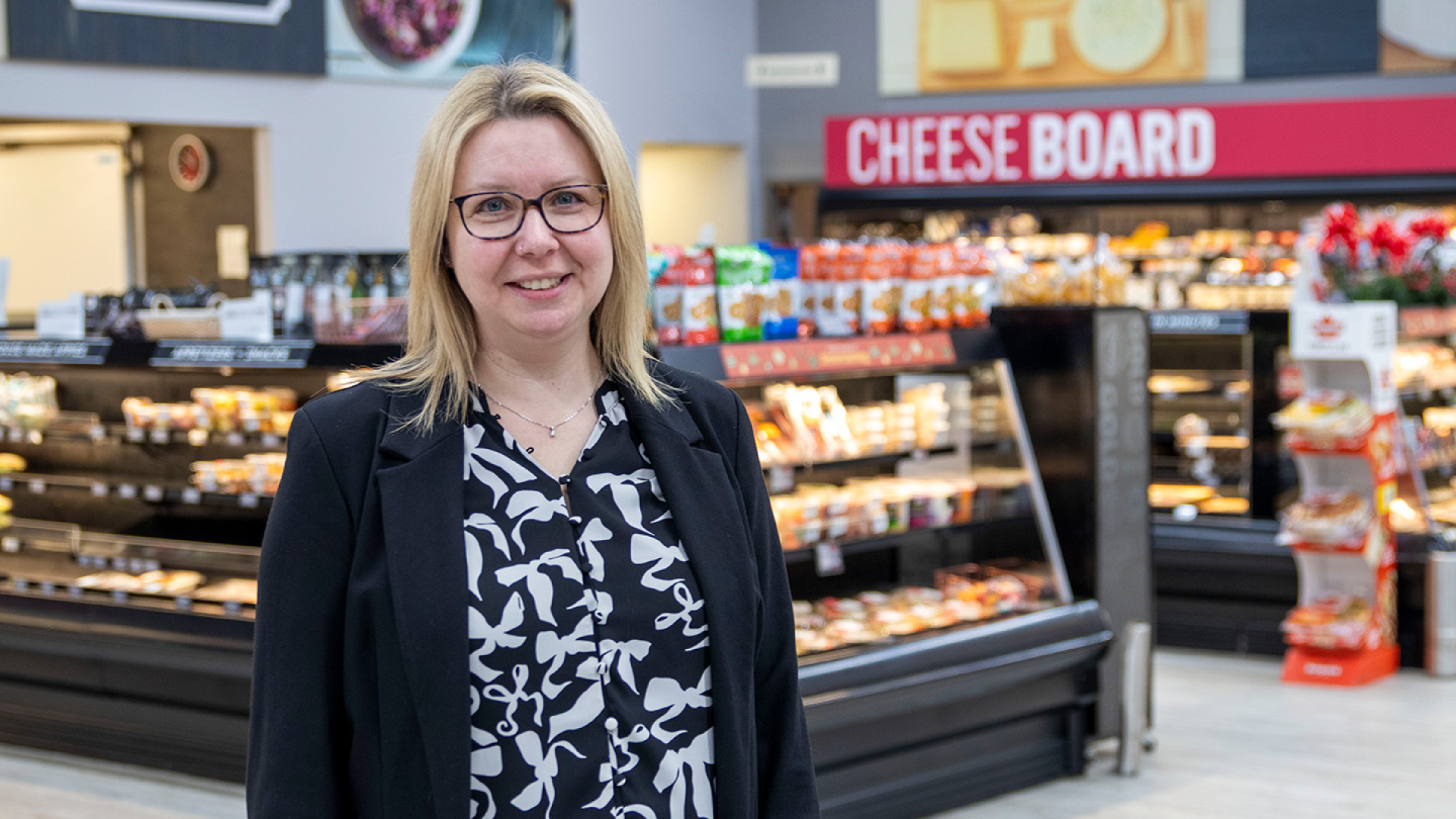 Leanne DeVliegere standing inside the Co-op store with a dairy aisle in the background.