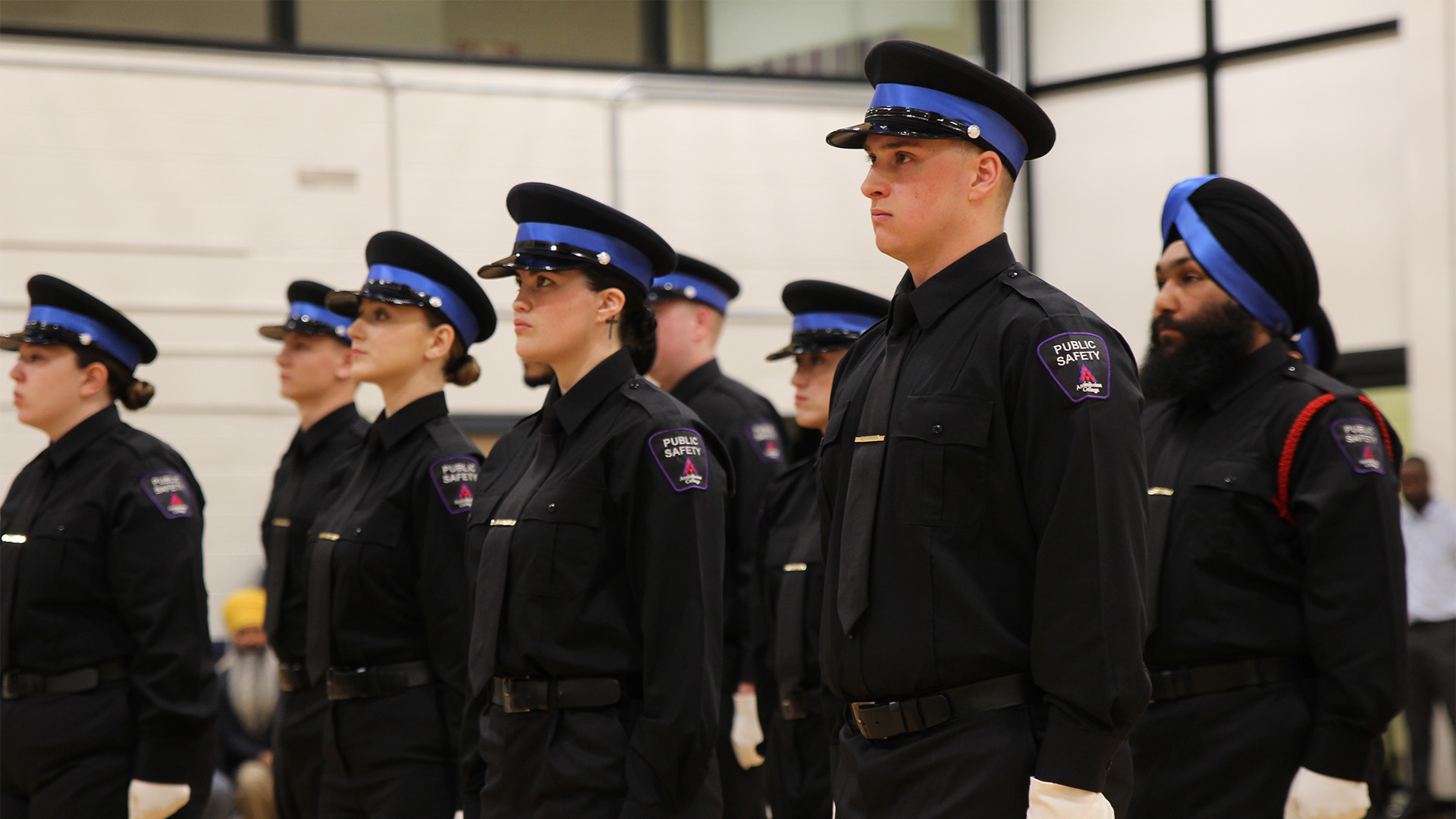 A group of Public Safety students in black uniforms standing in formation at the graduation ceremony.