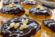 Closeup shot of chocolate-glazed donuts with peanuts.