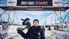 Randy Frykas standing with a shoulder-mounted camera at a starting point of a race.